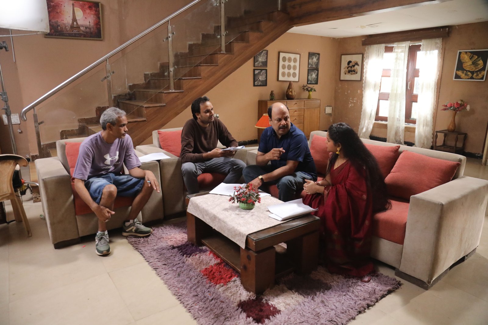 On-set script discussion with cast and crew, representing commercial and brand film production